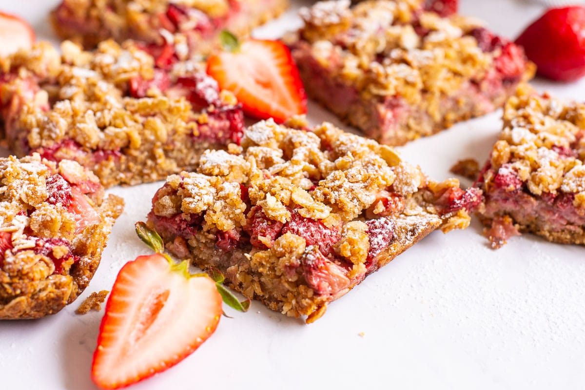 Healthy strawberry bars cut into squares with fresh strawberries.