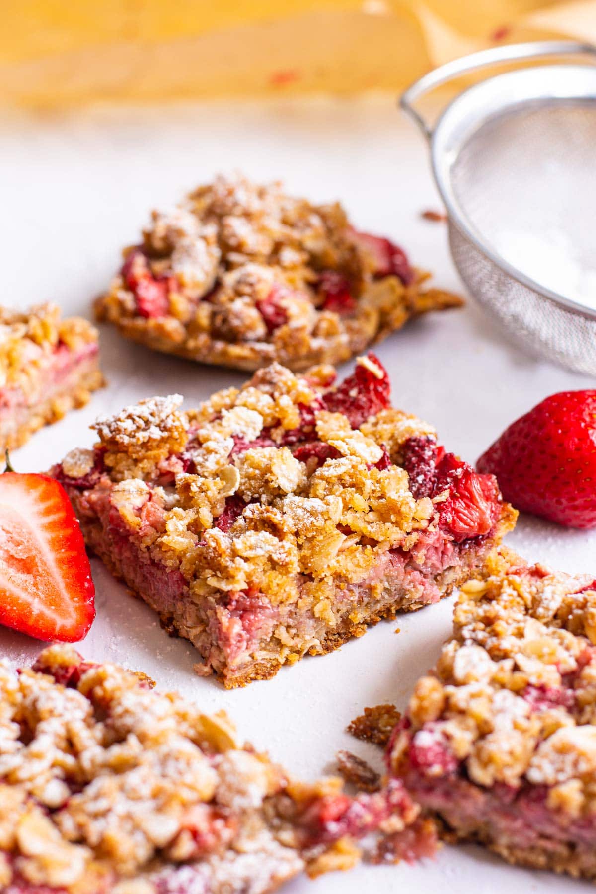 Healthy strawberry oatmeal bars cut into squares with fresh strawberries. 