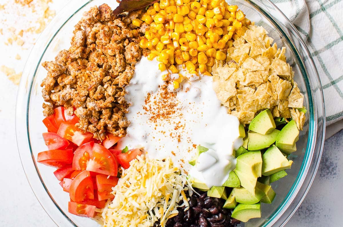 Tomatoes, cheese, black beans, avocado, crushed chips, corn and ground turkey with plain yogurt.