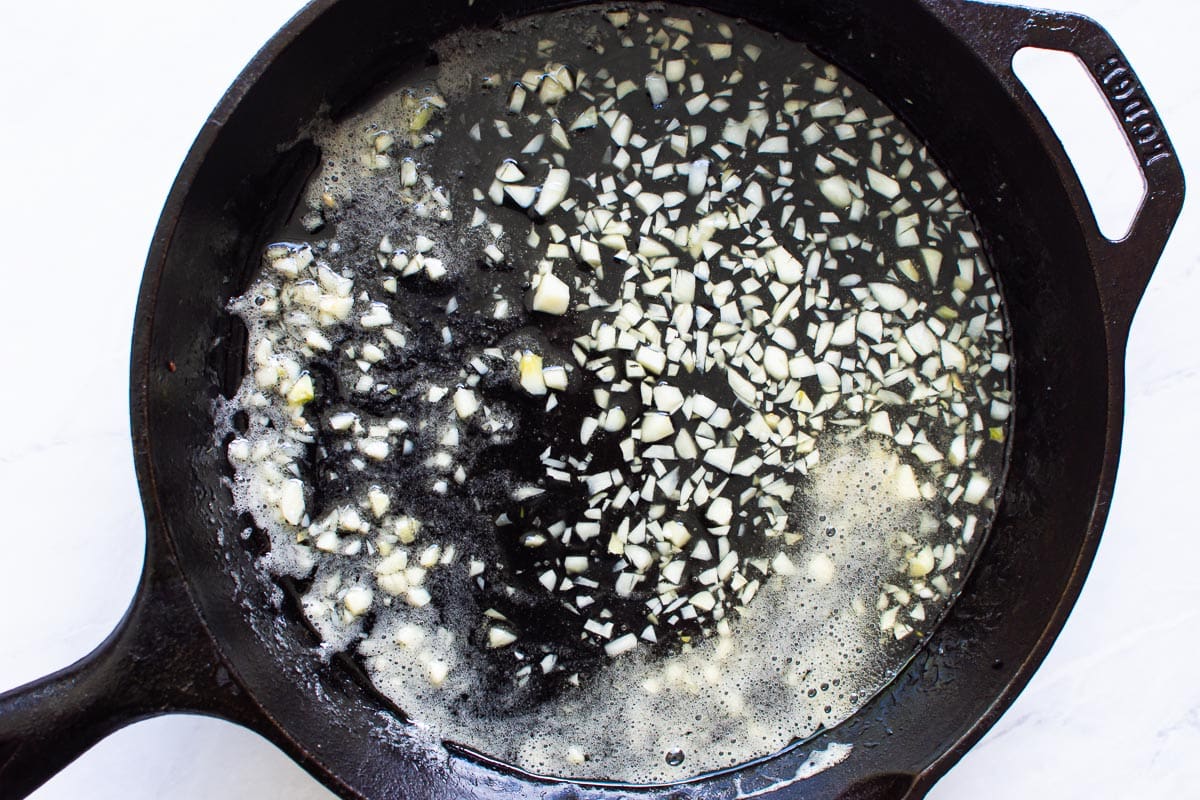 Cast iron skillet with oil, honey, lemon juice, water and garlic.