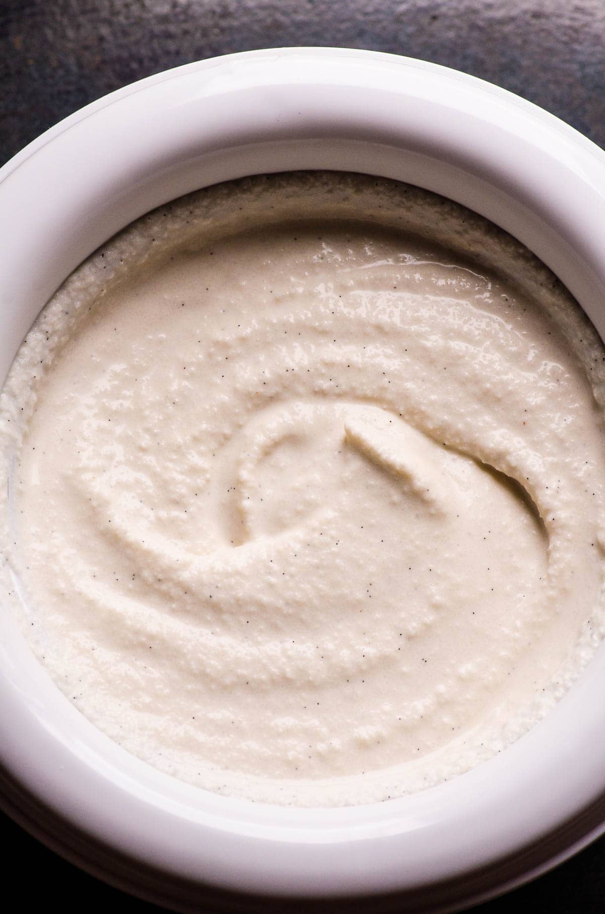 Vegan vanilla ice cream in bowl of ice cream maker.