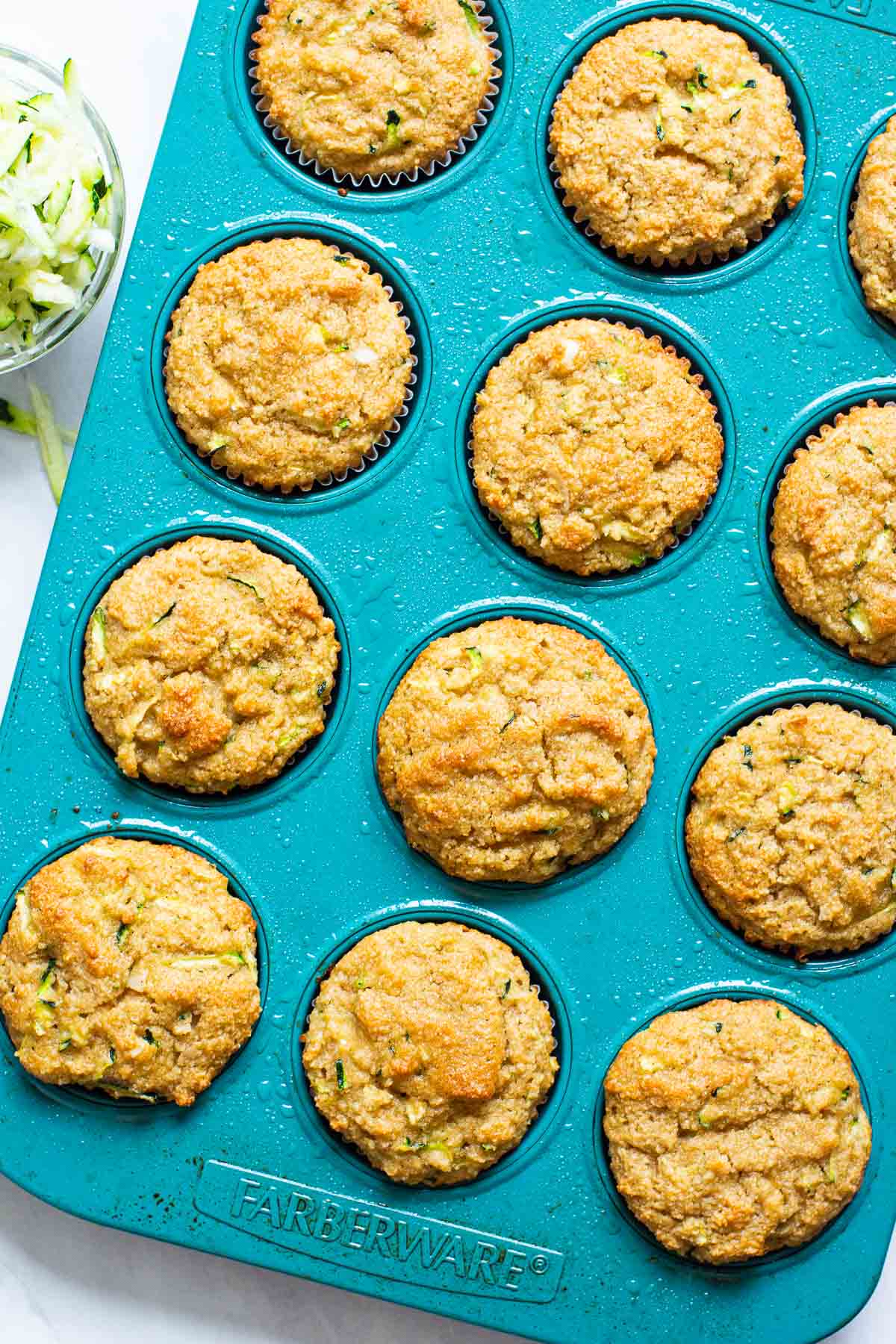 Almond flour zucchini muffins in blue muffin tin.