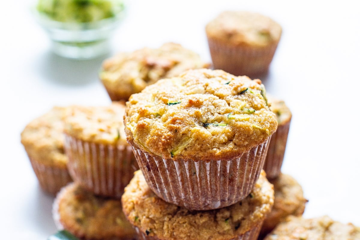 Almond flour zucchini muffins stacked on top each other.