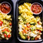 Black containers with healthy breakfast meal prep and little jars with salsa.