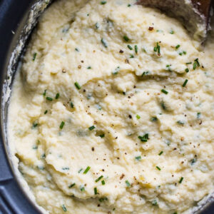 Slow cooker cauliflower mashed potatoes garnished with chives.
