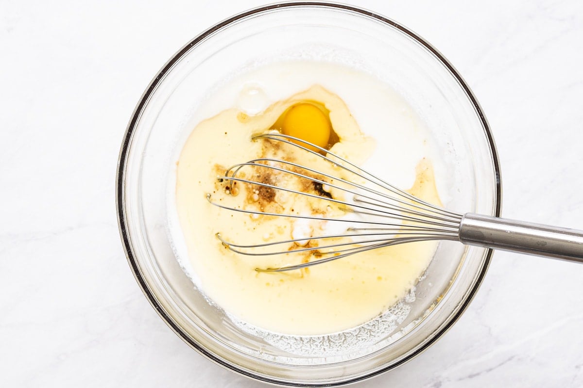 Eggs, buttermilk, maple syrup, oil and vanilla in bowl.