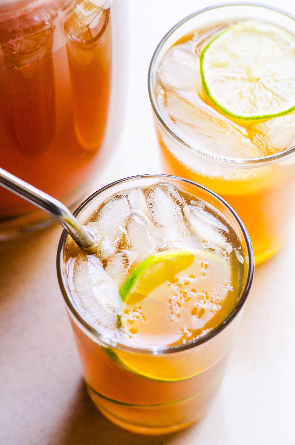 Healthy iced tea in a glass with a lime slice and metal straw.