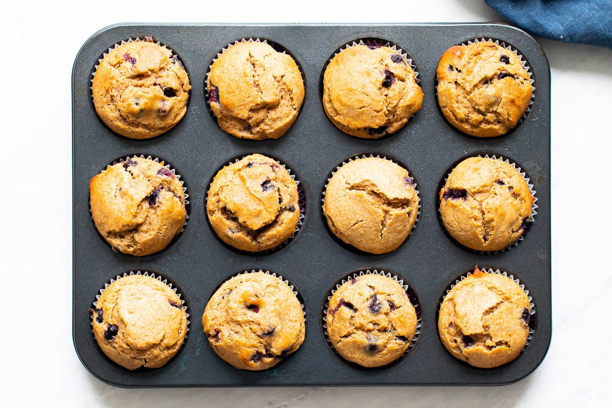Healthy lemon blueberry muffins in a gray muffin tin.