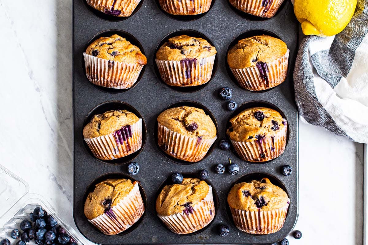 Healthy lemon blueberry muffins in a muffin tin.