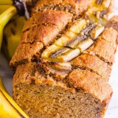 Healthy banana bread recipe sliced with fresh banana.