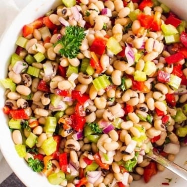 Easy white bean salad in a white bowl with serving spoon.