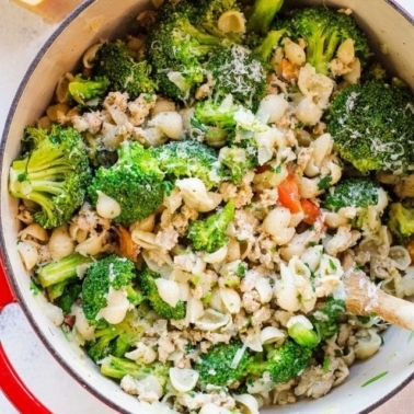 Ground turkey and broccoli pasta in a pot with Parmesan cheese.