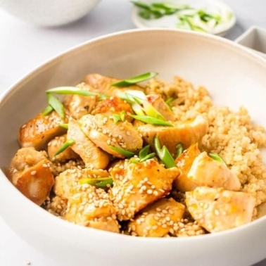 Healthy orange chicken in a bowl with sesame seeds.