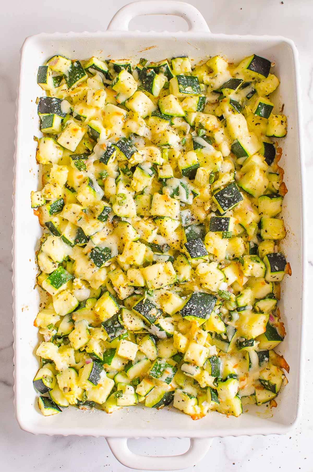 Healthy zucchini casserole baked in a white dish.