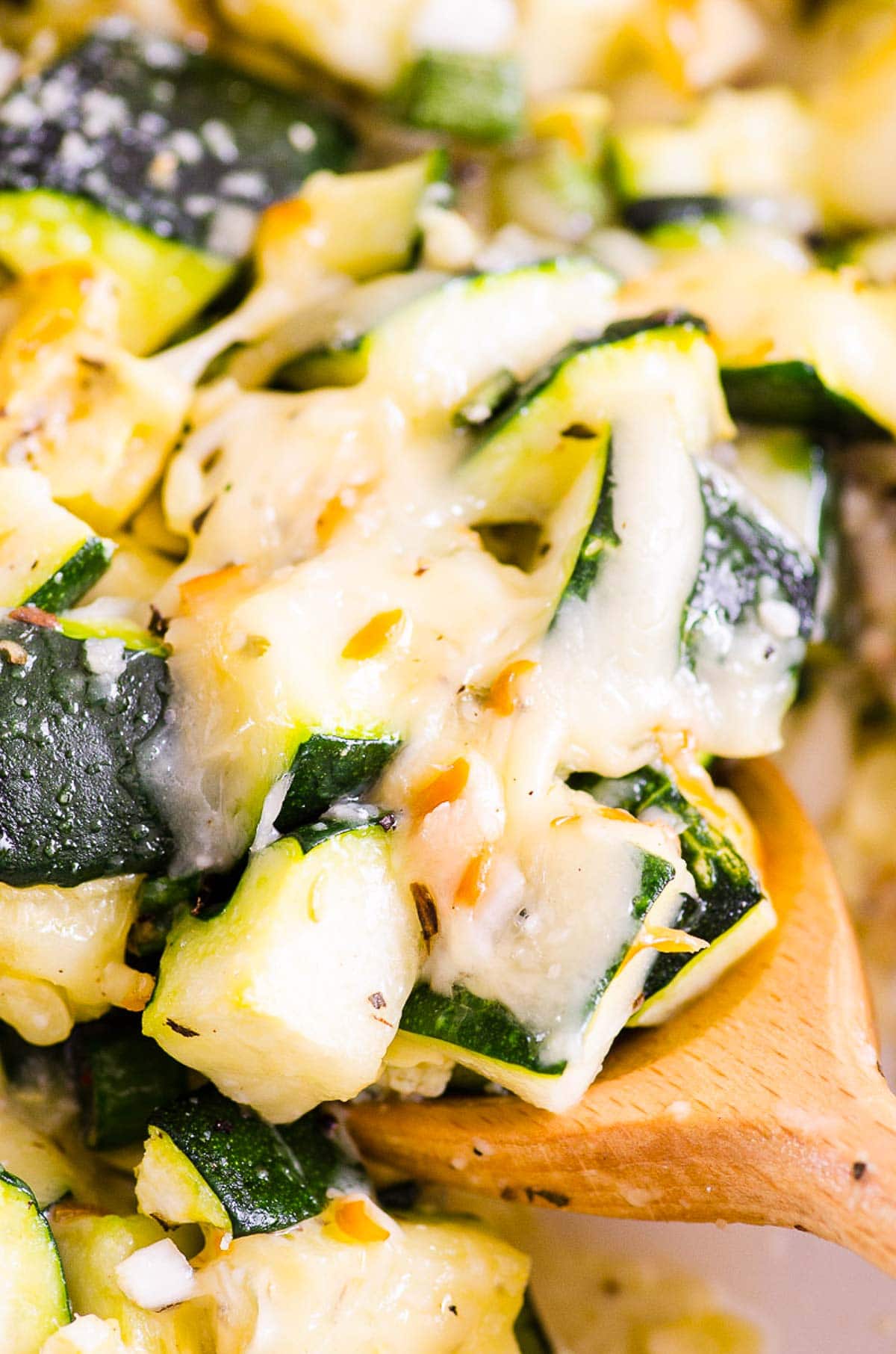 Close up of healthy zucchini casserole on a serving spoon.