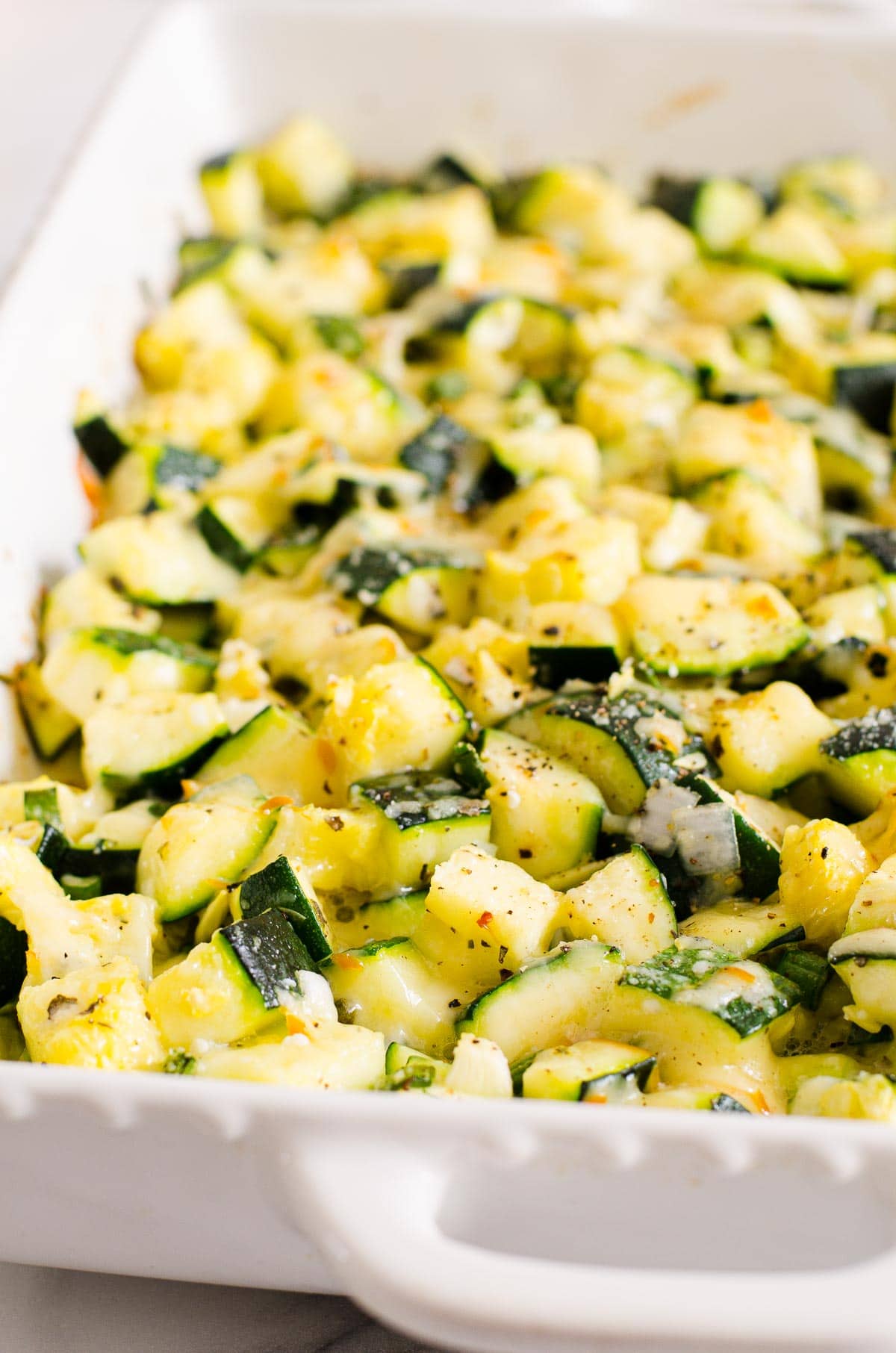 Healthy zucchini casserole in white baking dish.