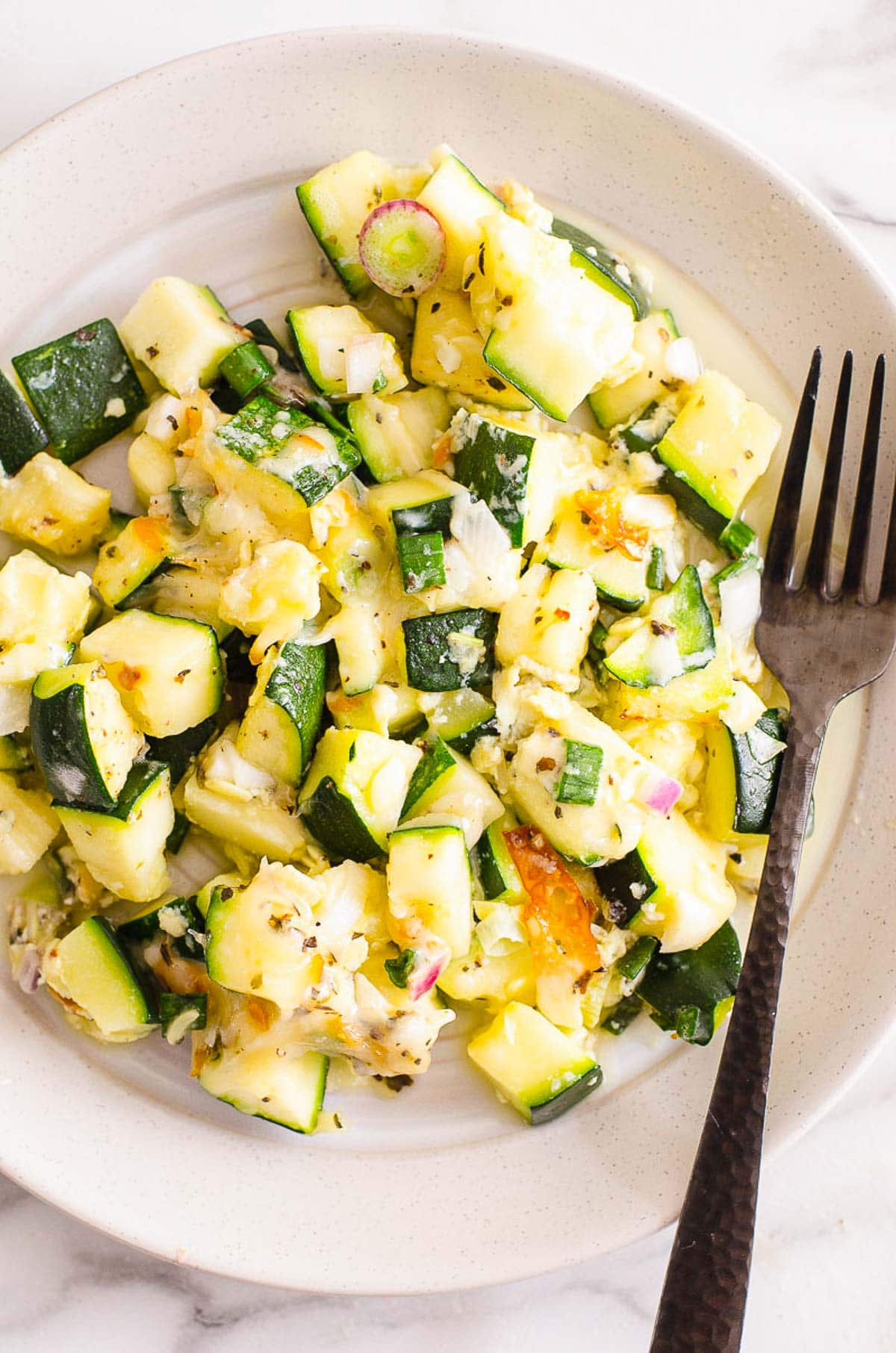 Zucchini casserole on plate with fork.