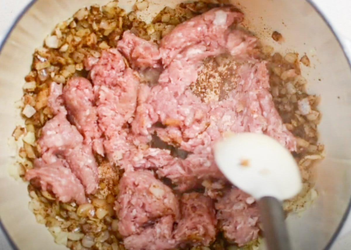 Ground turkey with onion and seasonings stirred in a pot.