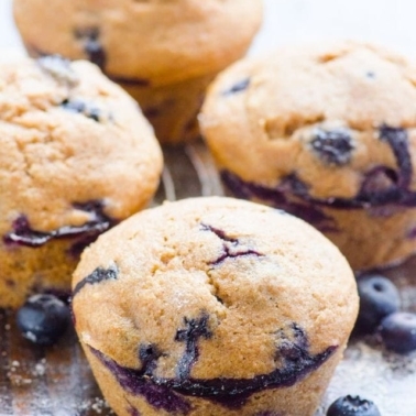 Healthy blueberry muffins recipe on counter with fresh berries.