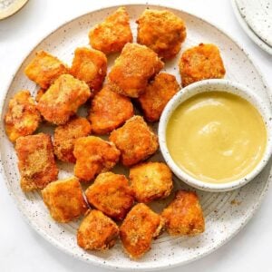 Healthy chicken nuggets on a plate with dipping sauce.