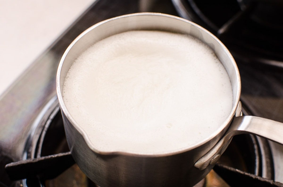 Heated milk in small pot.