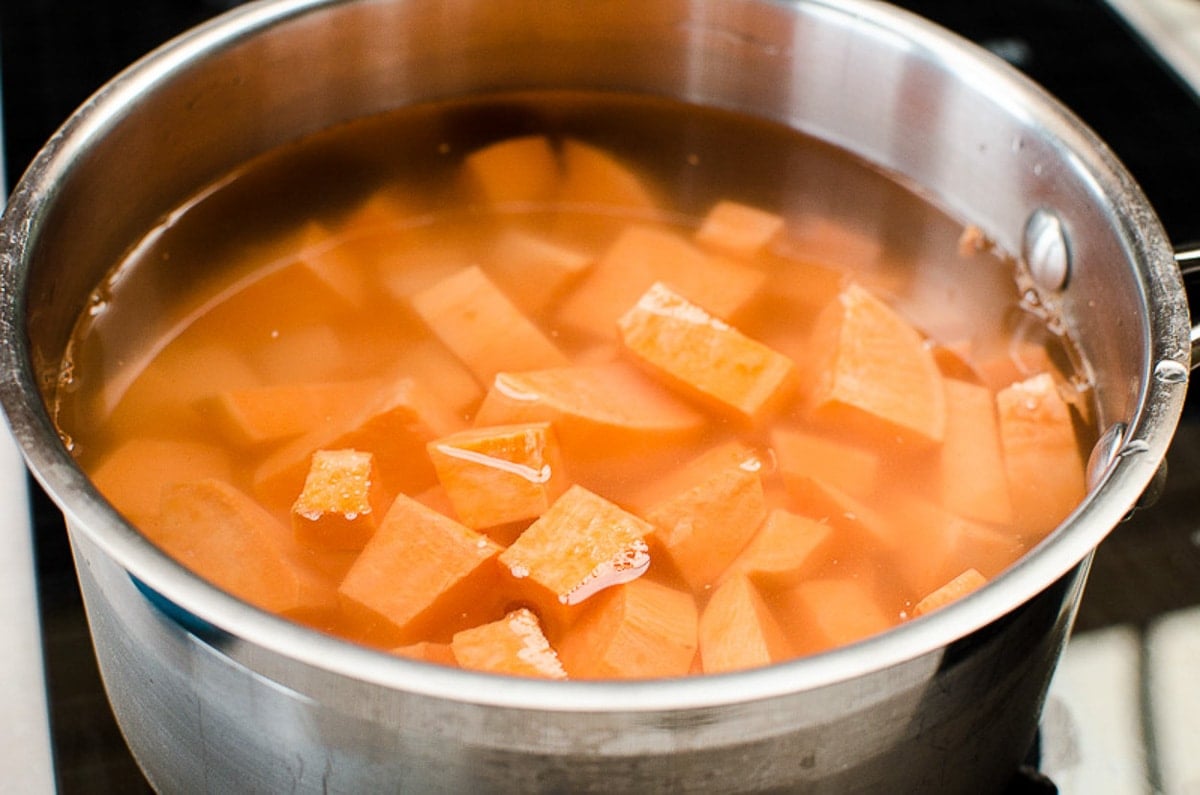Boiled sweet potato cubes in a pot with water.