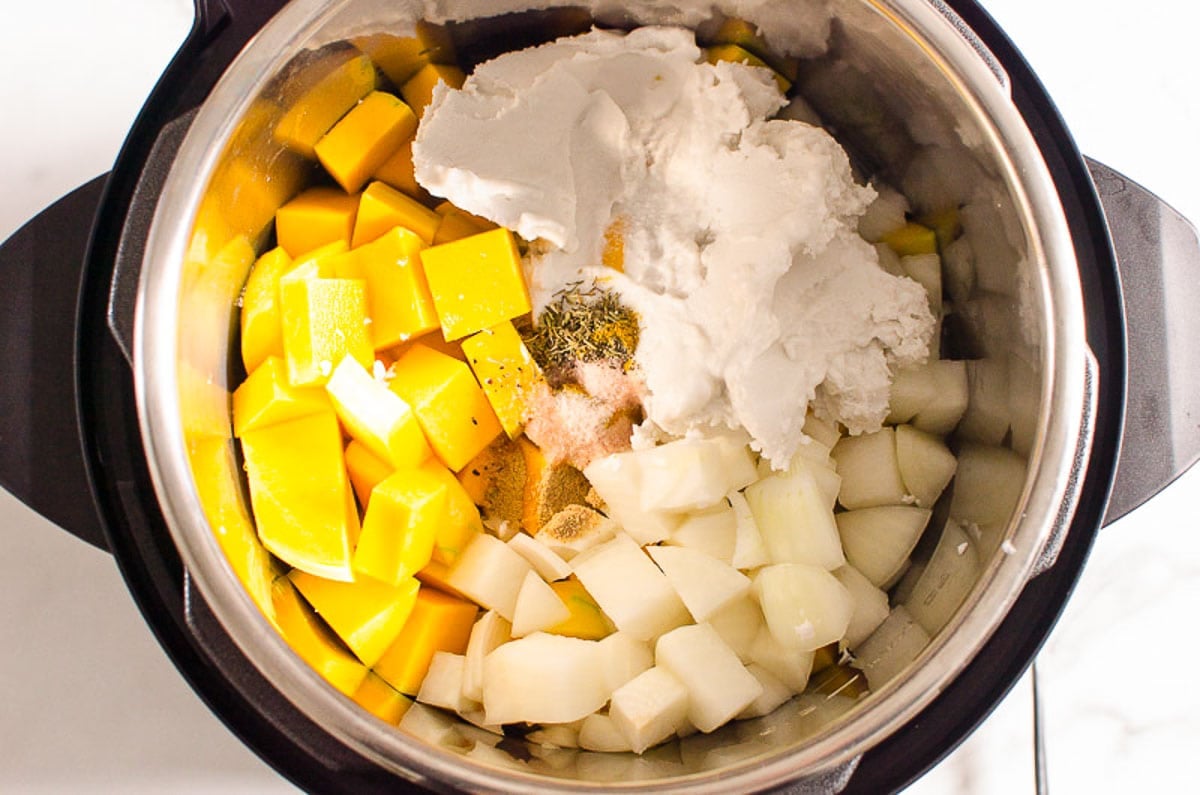 Cubed butternut squash, coconut milk, seasonings, cubed onion in pressure cooker.