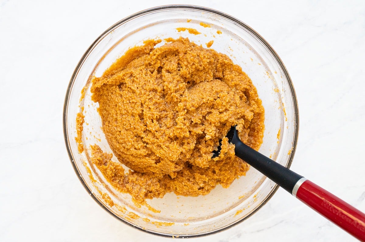 Pumpkin muffin batter in a bowl with a spatula. 