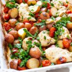 One pan chicken and potatoes in baking dish with fresh parsely.