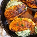 Spinach stuffed chicken breasts in cast iron skillet.