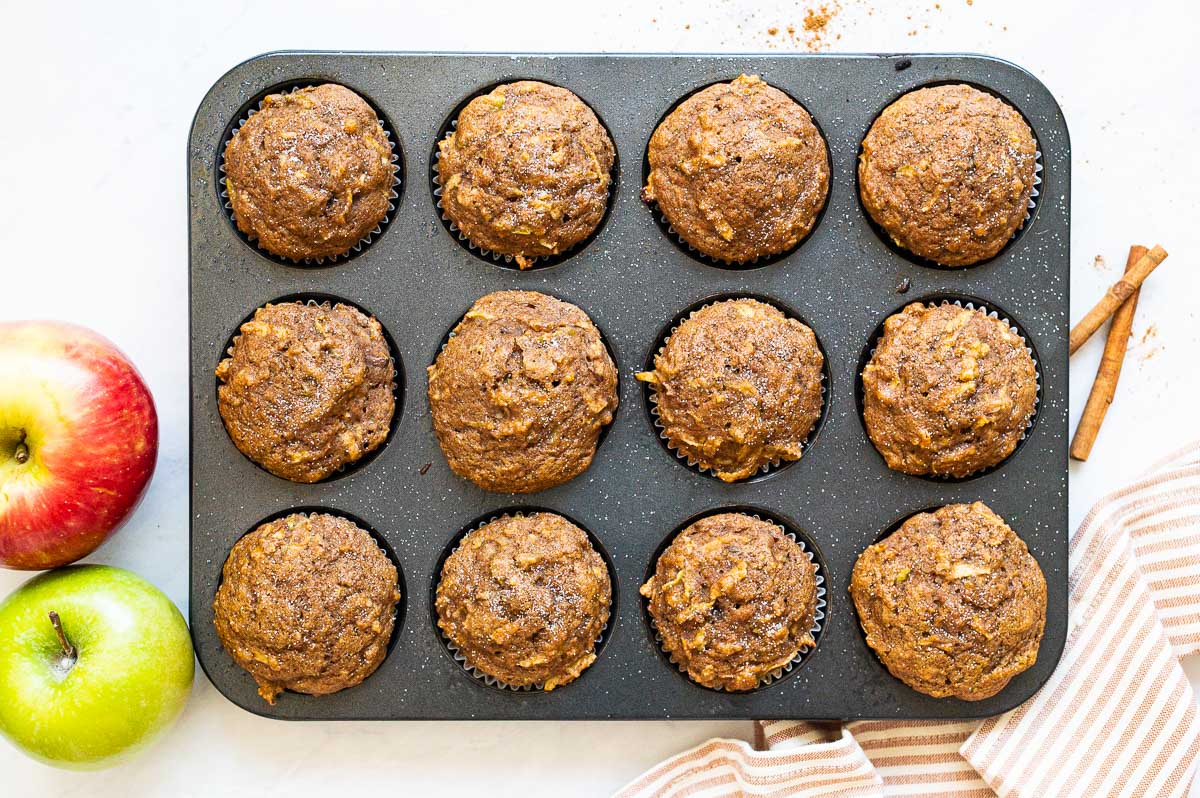 Healthy apple muffins sprinkled with sugar in a muffin tin.