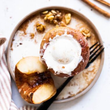 Healthy baked apples on a plate with ice cream.