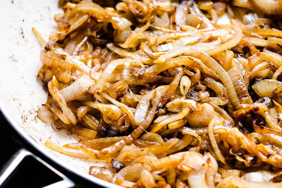 Caramelized onions in white skillet.