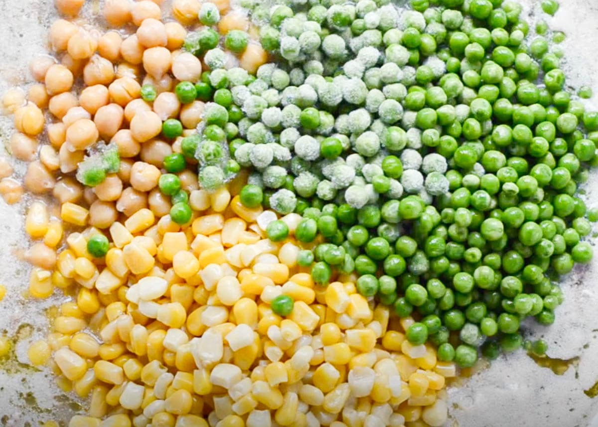 Frozen corn, peas and chickpeas with sauce and meat.