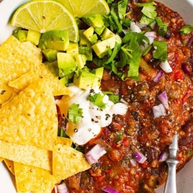 Instant Pot vegetarian chili with lime, tortilla chip, yogurt, cilantro garnish.