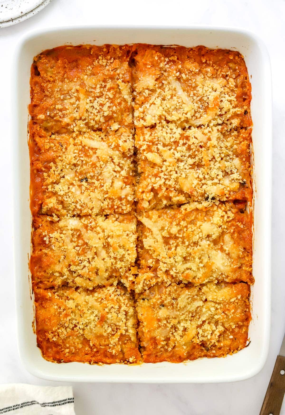 Spaghetti squash casserole in white baking dish and cut into rectangles for serving.