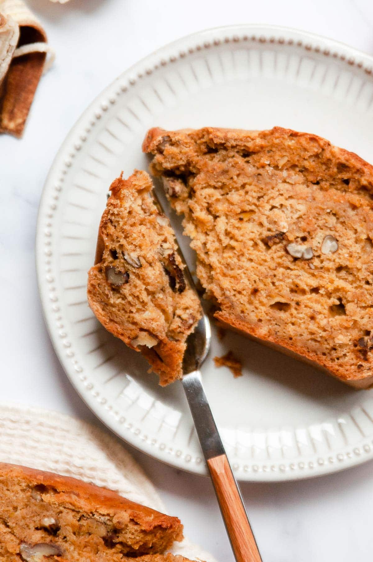 A slice of quick bread on plate with fork.