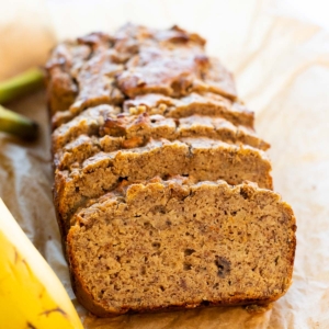 Sliced coconut flour banana bread loaf on parchment paper.