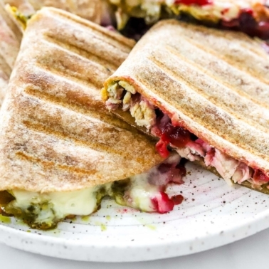 Leftover turkey quesadillas with pesto, cranberry sauce and melted cheese on a plate.