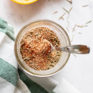 Turkey breast rub seasoning in a glass jar with a spoon.