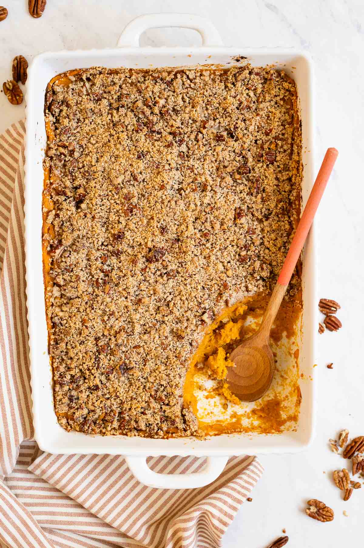 Healthy sweet potato casserole with a wooden spoon in baking dish.