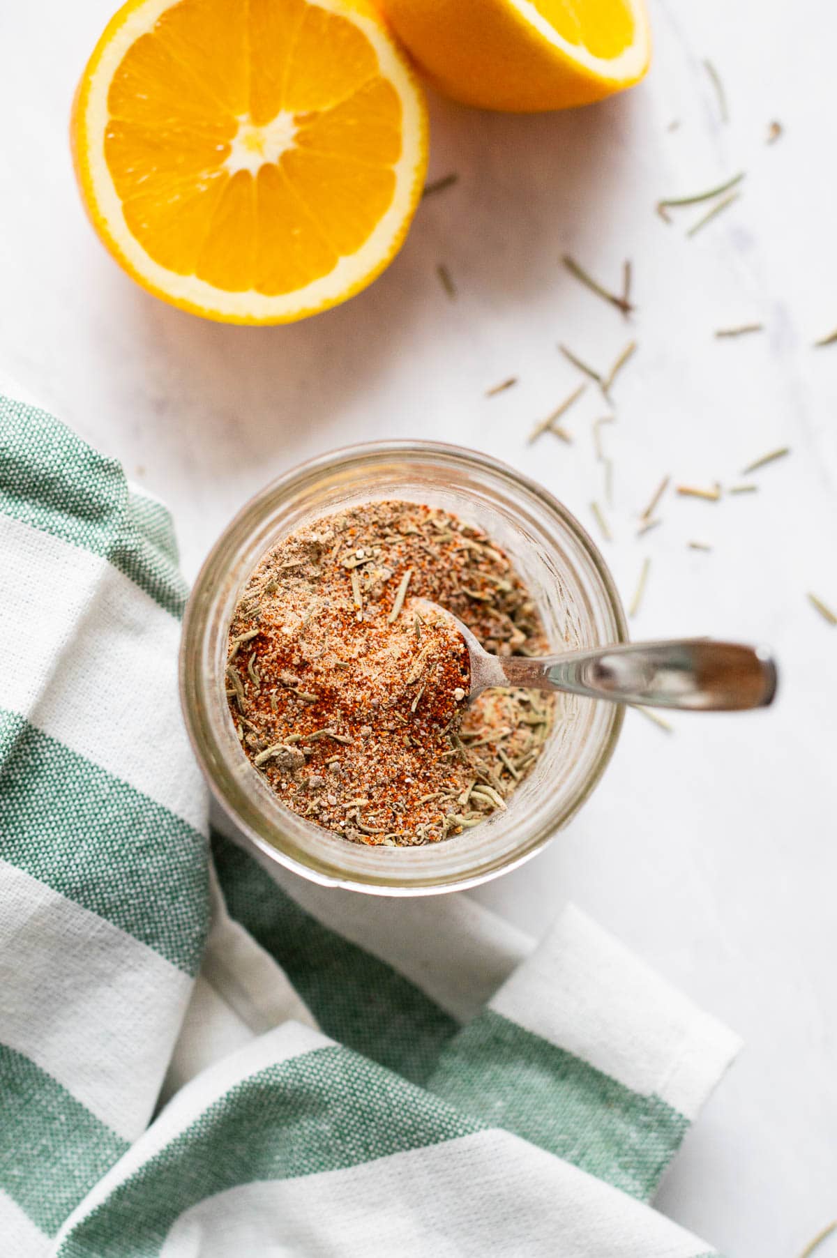 Turkey breast rub seasoning in a glass jar with a spoon.