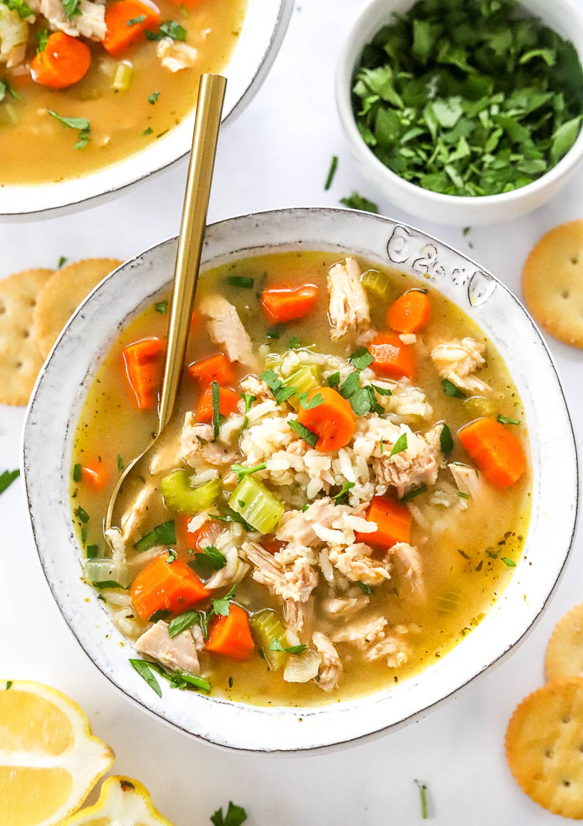 A bowl with leftover turkey rice soup garnished with parsley.