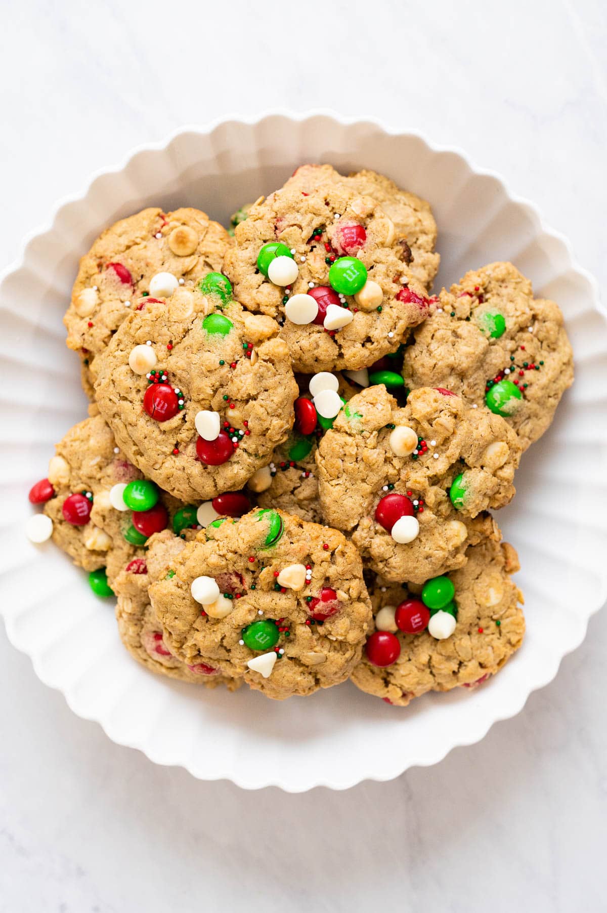 Holiday cookies with sprinkles on white plate.