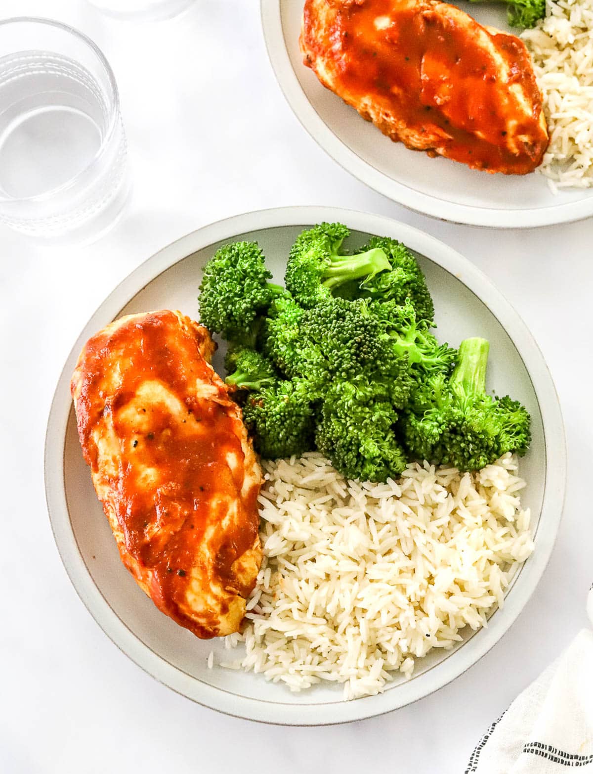 Instant Pot BBQ chicken breast with rice and broccoli on a plate.