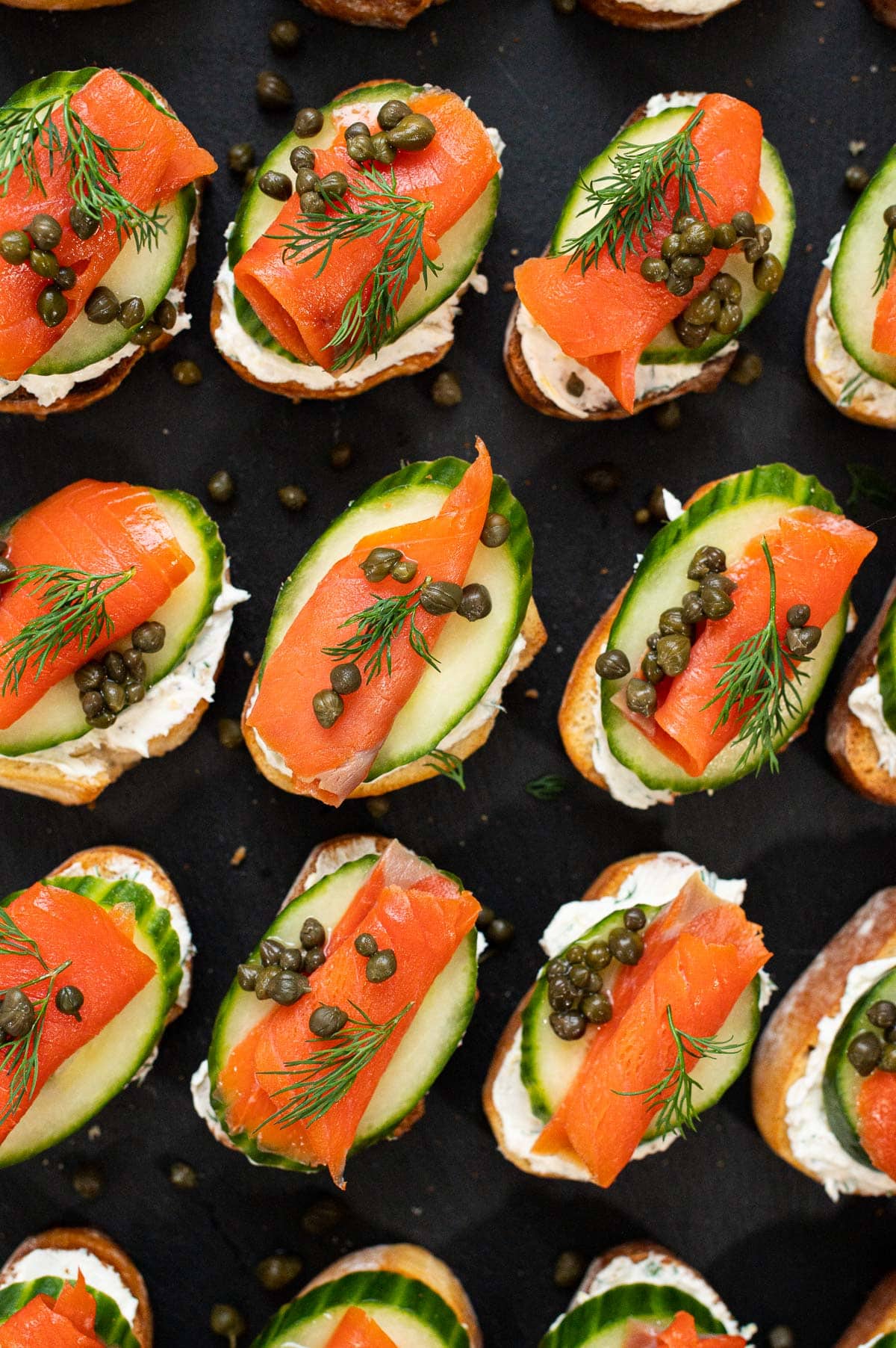 Smoked salmon crostini with cucumber, cream cheese, capers and dill.