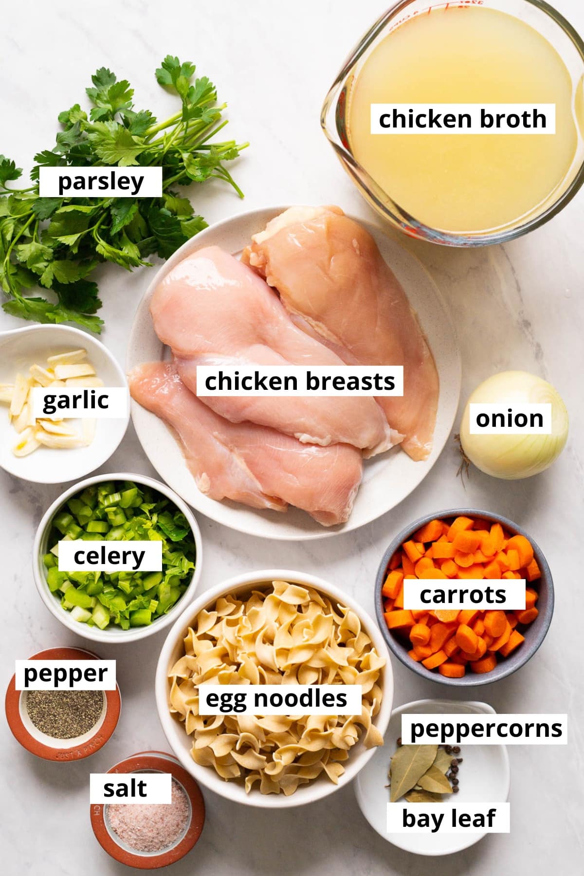 Chicken breasts, chicken broth, parsley, garlic, onion, carrots, celery, egg noodles, peppercorns, bay leaf, salt, pepper.