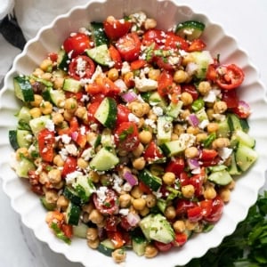 Mediterranean chickpea salad with feta in white bowl.