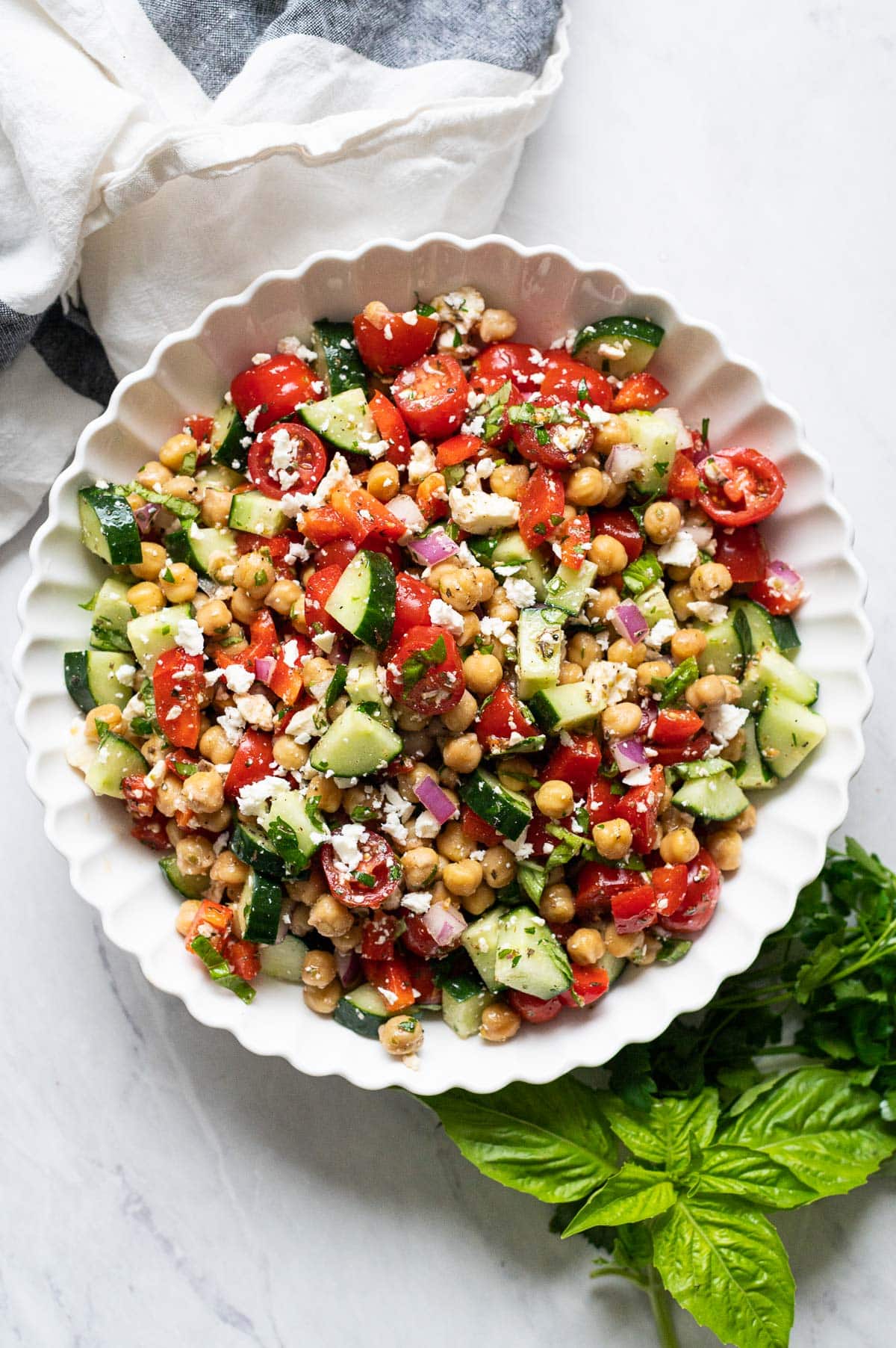 Mediterranean chickpea salad with feta in white bowl.