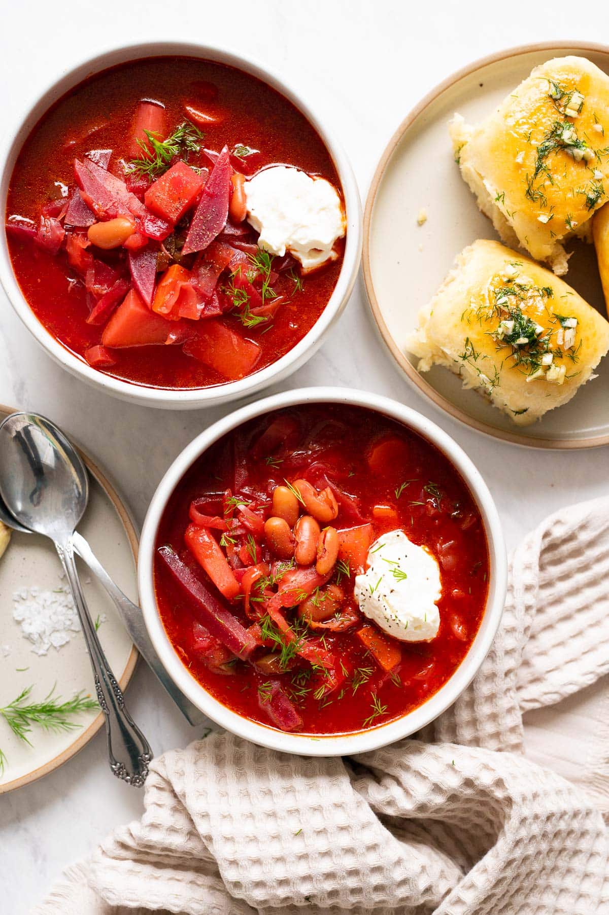 Vegetarian borscht served in a bowl with sour cream and dill.